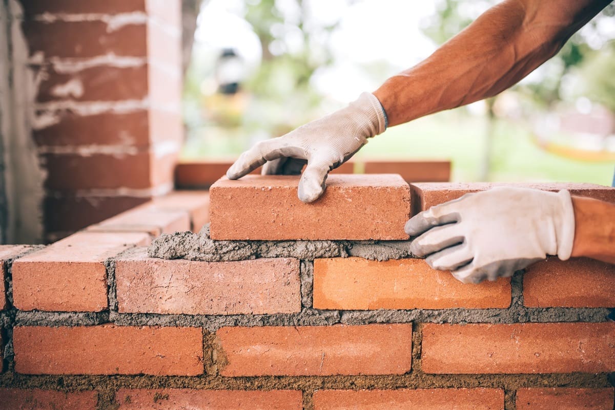 Owners (or workers) inspecting or handling bricks directly.